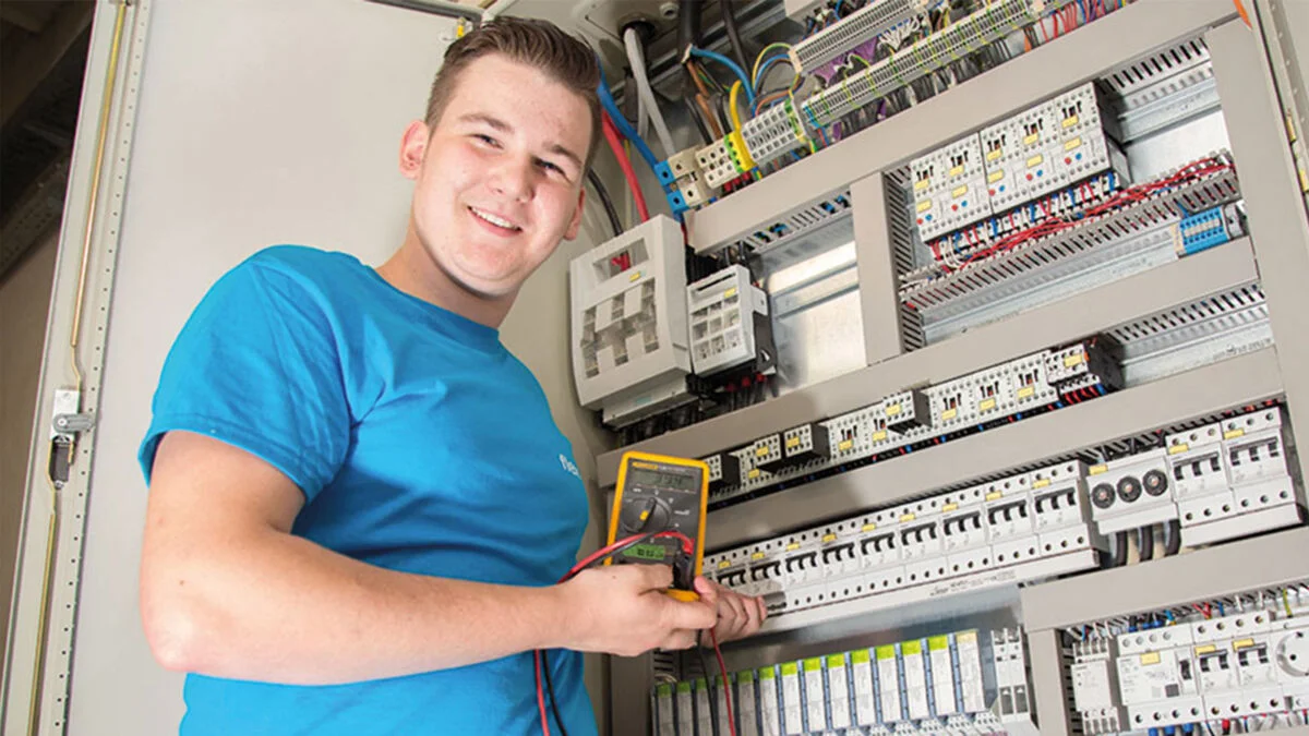 Male apprentice calibrating a machine