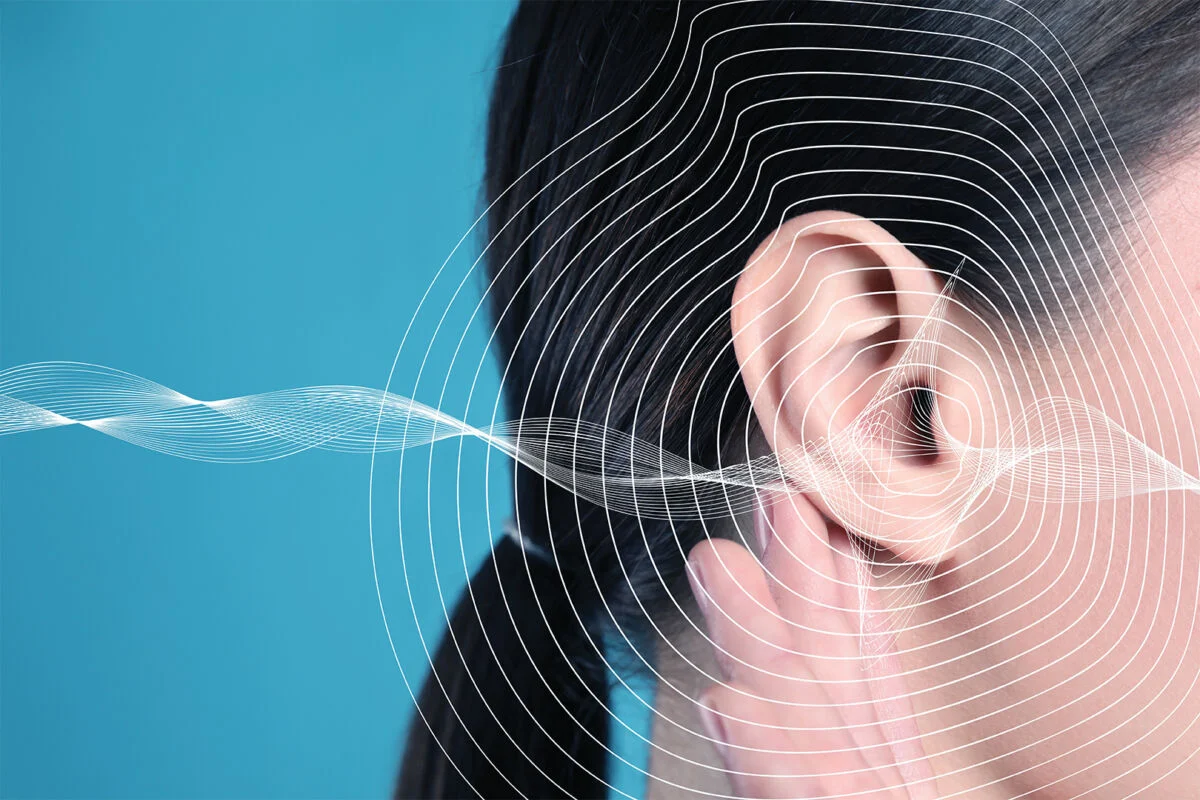Person holding ear with lines showing soundwaves